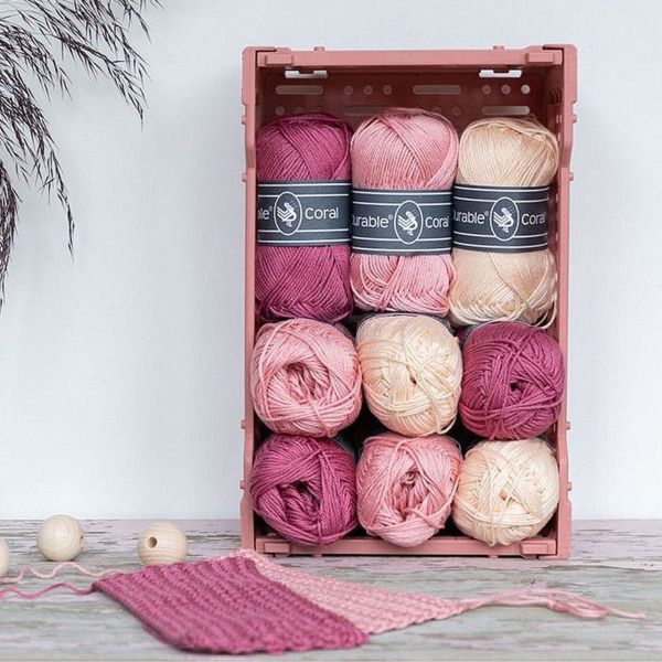 diverse durable coral katoen bollen met pastel kleuren in kratje - sfeerbeeld
